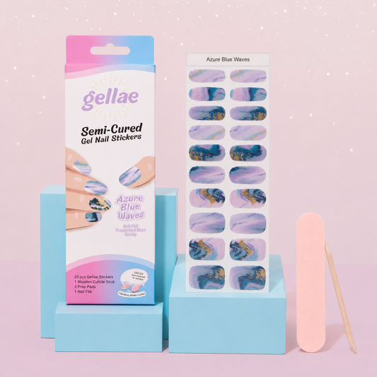Gellae Semi-Cured Gel Nail Stickers in 'Azure Blue Waves' set, featuring the retail box, a sheet of decorative nail stickers, a pink nail file, and a wooden stick on light blue display blocks against a pink background.