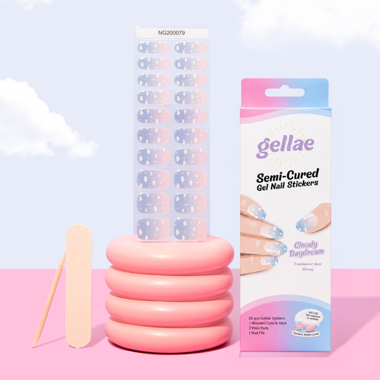 Gellae semi-cured gel nail sticker kit featuring a stack of pink rings, a wooden nail stick, a sheet of nail stickers, and the retail packaging box against a pastel sky and clouds background.