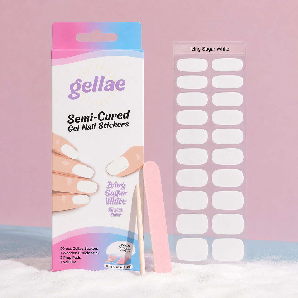 Gellae Semi-Cured Gel Nail Stickers in Icing Sugar White, showing the retail packaging, a sheet of white oval-shaped stickers, a pink cuticle stick, and a pink nail file on a pink and white background.